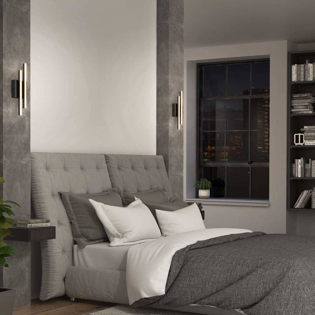 Modern bedroom with a tufted gray headboard, gray and white bedding, two wall-mounted sconce lights, a bookshelf, and a large window showing a cityscape at night. A small plant sits on the windowsill.