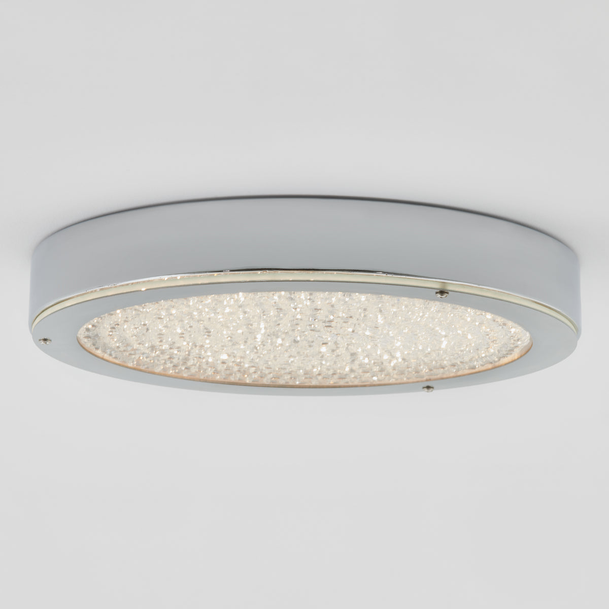 A modern round ceiling light fixture with a metallic silver frame and a textured, crystal-like surface in the center, mounted against a plain white ceiling.