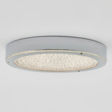 A modern round ceiling light fixture with a metallic silver frame and a textured, crystal-like surface in the center, mounted against a plain white ceiling.