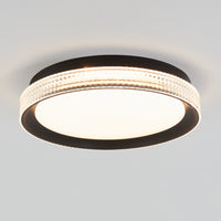 The Artika Aston 15 in. LED modern flush mount light features a black frame, textured clear ring, and white illuminated center, mounted on a plain white ceiling.