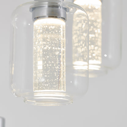Close-up of the Artika Champagne Globe 4-light LED pendant, featuring clear cylindrical glass shades with bubble-filled inner tubes, brightly illuminated against a neutral background.