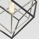 A geometric pendant light fixture with intersecting black and silver metal frames, housing an exposed vintage-style filament bulb, set against a plain white background.