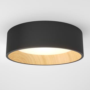 The Artika Alton LED flush mount features a black outer rim, light wood inner rim, and white diffused surface. This dimmable ceiling fixture offers stylish modern lighting when mounted on a white ceiling.