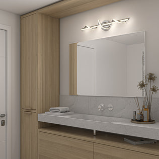 Modern bathroom with light wood cabinets, large mirror, gray stone countertop, wall-mounted faucet, folded towels, and a vase with dried flowers illuminated by the Artika Coda 27-in Integrated LED 5-CCT Vanity Light Bar above the vanity.