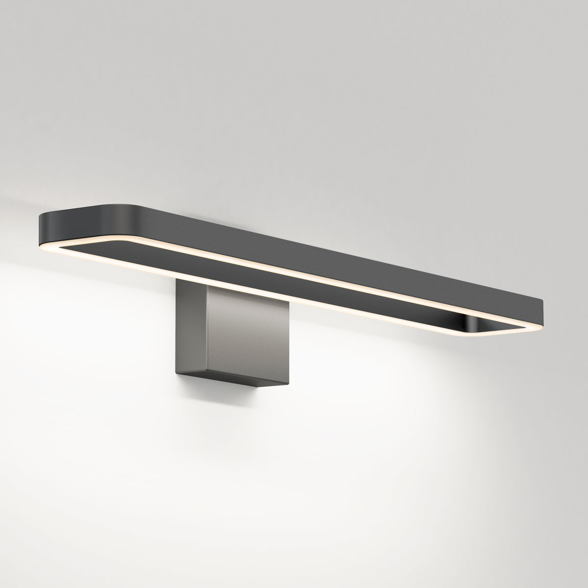 A modern, rectangular wall-mounted light fixture with a sleek black frame and integrated LED lighting, emitting a soft, even glow on a plain white wall.