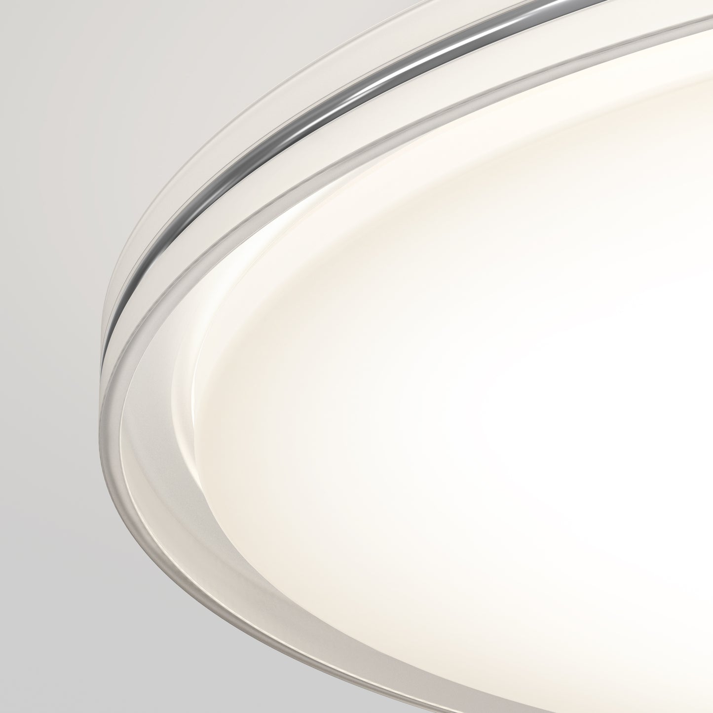 Close-up of the Artika Astrid 16.5 in. LED flush mount light with a frosted glass cover and metallic rim, brightly illuminated against a light grey background; features 5 CCT settings and comes with a remote.