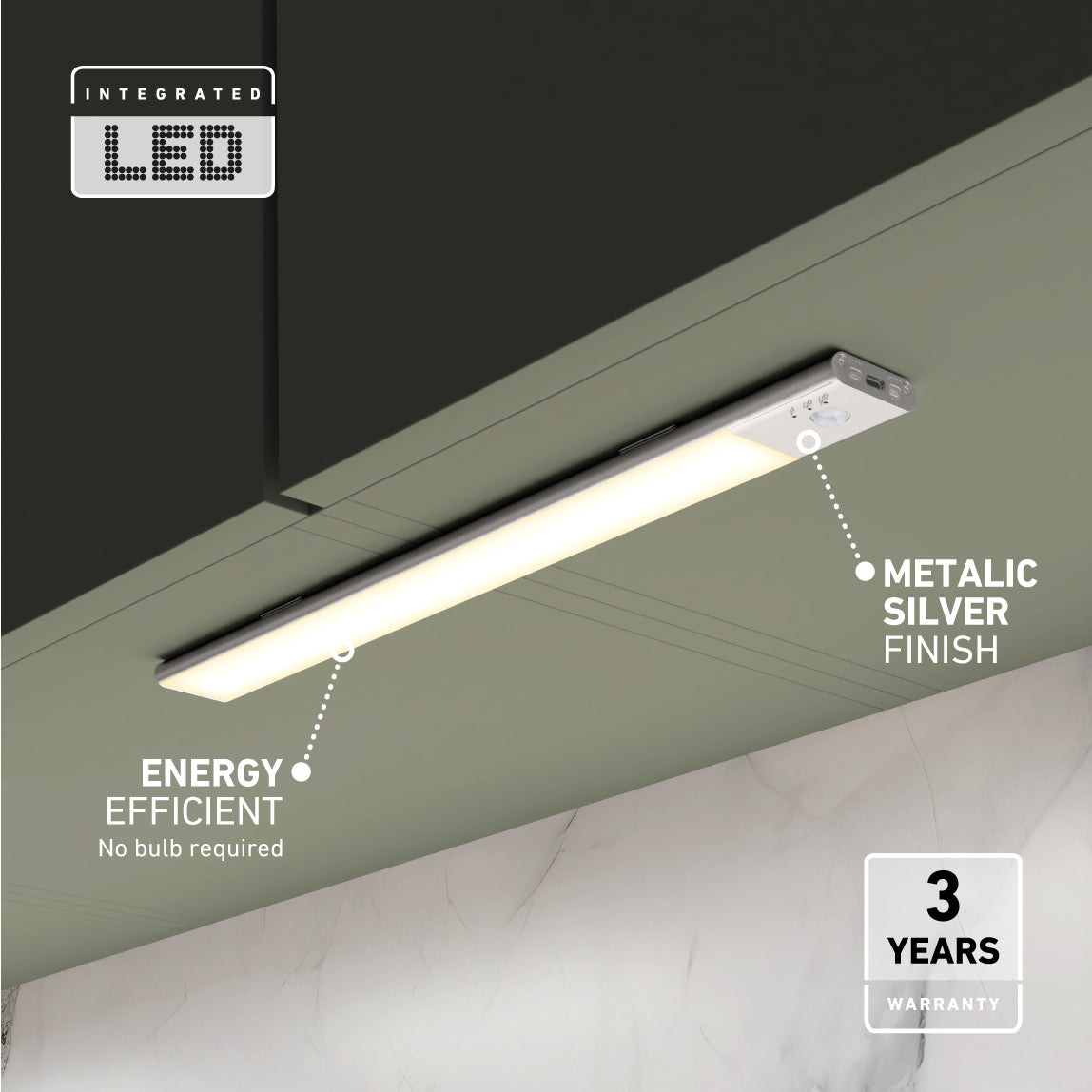 A sleek, integrated LED light bar with a metallic silver finish is mounted under a dark cabinet. Text highlights its energy efficiency, metal finish, and 3-year warranty. The background includes a marble wall.