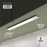 A sleek, integrated LED light bar with a metallic silver finish is mounted under a dark cabinet. Text highlights its energy efficiency, metal finish, and 3-year warranty. The background includes a marble wall.