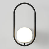 A modern wall sconce with a black oval frame encircling a glowing white spherical light bulb, mounted on a plain light gray wall.