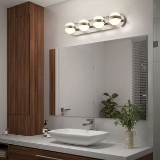 Modern bathroom with wooden cabinets, vessel sink, potted plant & a rectangular mirror lit by Artika’s Baldric LED vanity light (3 CCT).
