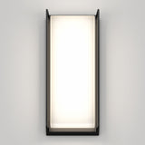 A modern rectangular wall sconce with a black frame and frosted glass, emitting a soft white light, mounted on a plain light gray wall.