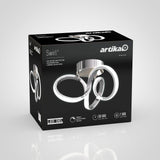 A black box with artika branding displays the Swirl LED ceiling light fixture, featuring a sleek, modern spiral design and product details such as 50,000-hour lifespan and 1,500 lumens on the packaging.