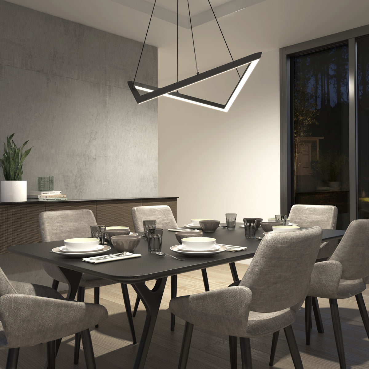 A modern dining room with a rectangular black table set for six, surrounded by cushioned gray chairs. A geometric chandelier hangs above, and a large window and potted plant are visible in the background.