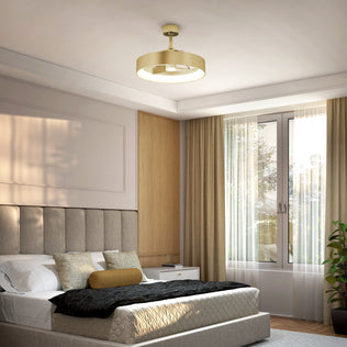 Modern bedroom with a taupe upholstered bed, neutral bedding, gold accent pillow, nightstand, and large window with sheer curtains. A plant sits in the corner beneath the Artika Austin 23 in. LED modern ceiling fan with remote.