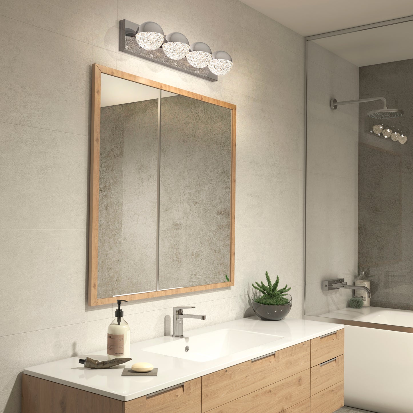 Modern bathroom with a large wooden-framed mirror, white countertop, soap dispenser, potted succulent, sleek faucet, and Artika Carat LED bathroom vanity light above the mirror; gray tiled walls and partial view of shower.