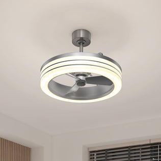 The Artika Horizon 23 in. LED modern ceiling fan with 3 speeds and a remote features silver blades and a circular LED light, mounted on a white ceiling above a window with partially opened blinds.