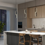 Modern kitchen with a marble island, black and wood cabinetry, three pendant lights, built-in oven, black faucet, and city view through large windows. Three wooden chairs are placed at the island.