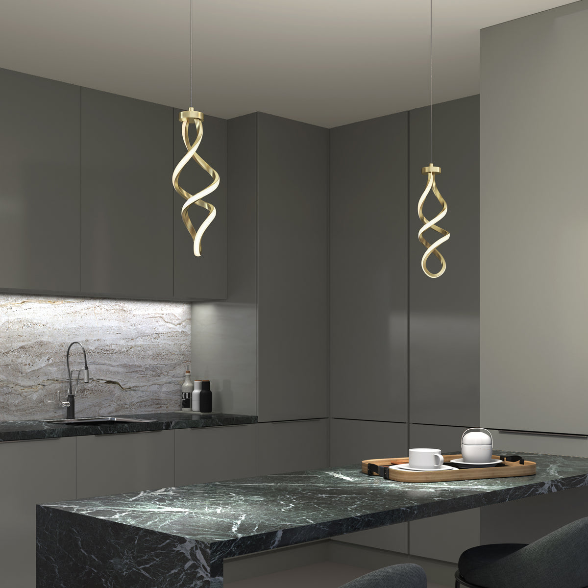 Modern kitchen with dark cabinetry and a marble countertop. Two sculptural, twisted pendant lights hang above the counter. The backsplash features a subtle marble pattern, and a tray with cups sits on the counter.