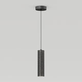 A modern black cylindrical pendant light hangs from the ceiling, featuring small perforations that create a star-like pattern on its surface.