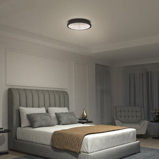 Modern bedroom with a gray upholstered bed, brown throw, and an Artika Glitter 14 in. LED Flush Mount Ceiling Light (2100 lumens).