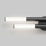 Minimalist wall-mounted light fixture with two cylindrical, horizontal white LED tubes attached to a round black base on a plain gray background.