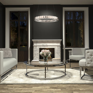 A modern living room features a white marble fireplace, two large windows, a round glass coffee table with flowers and books, white sofas, a plush rug, and the Artika Celebrity LED pendant light overhead.