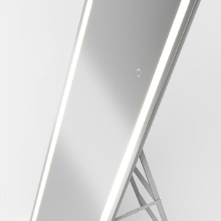 The Artika Emeraude 19"x59" full-length LED mirror stands on a minimal frame, ideal as a wall or floor accent.