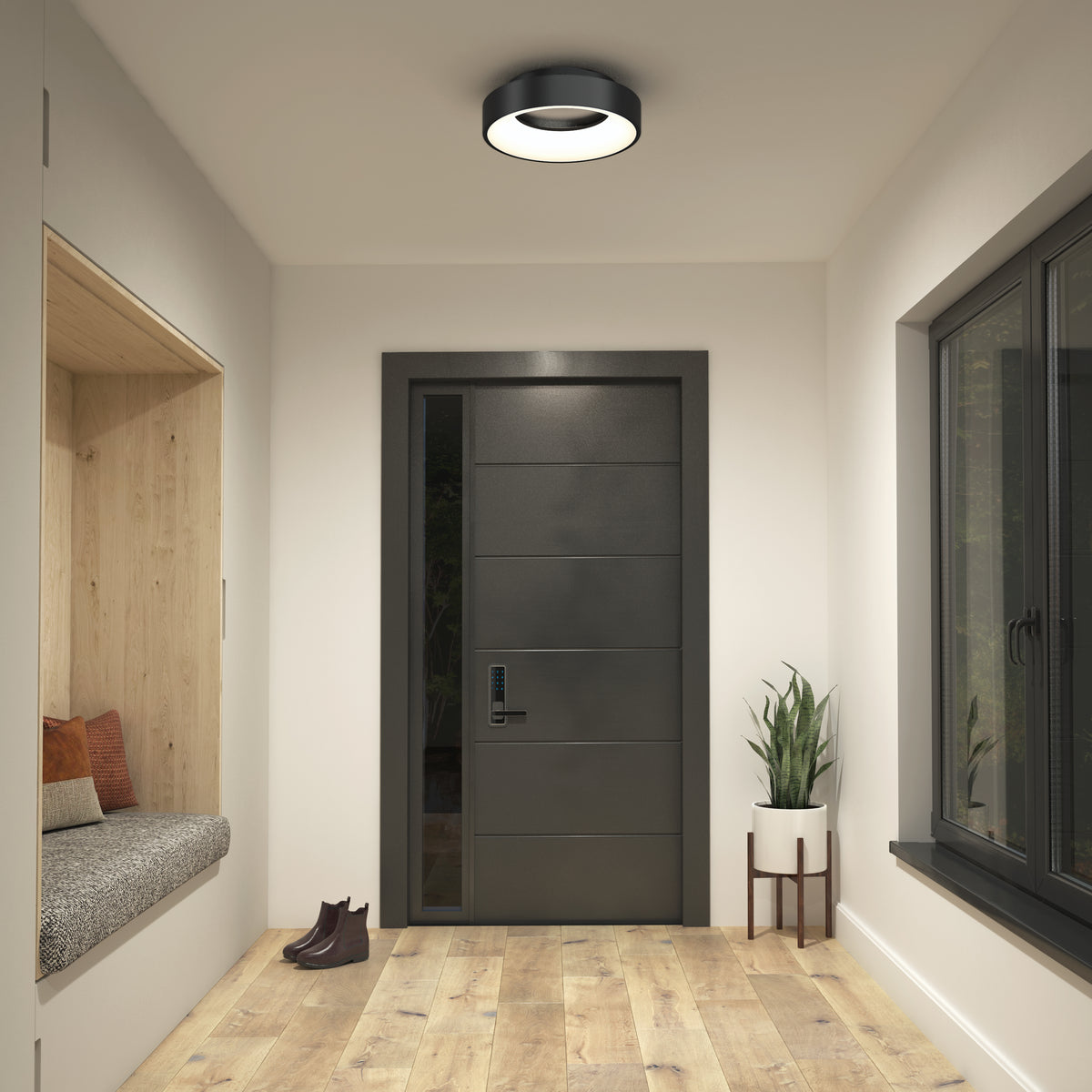 A modern entryway with a black front door, light wood floor, built-in bench with pillows on the left, plant stand to the right, Artikas Aiden LED flush mount overhead, and shoes placed by the bench.