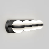 A modern wall-mounted light fixture with four evenly spaced, round white globes partially enclosed by a sleek, black horizontal frame against a plain light gray background.