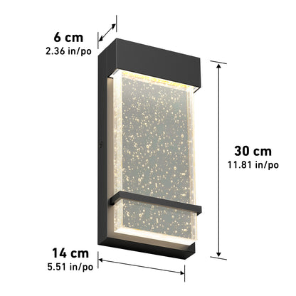 The Artika Skyler indoor-outdoor LED wall light is a rectangular black fixture with a clear, bubble-detailed panel, illuminated from within. Dimensions: 30 cm high, 14 cm wide, and 6 cm deep.