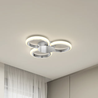 The Artika Nyala 15 in. LED flush mount light 5CCT features three illuminated rings and a metallic base, shown installed on a white ceiling in a minimalist room with sheer curtains and neutral walls.