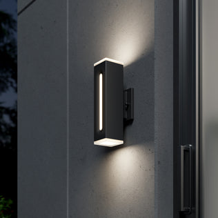 The Artika Linea Square LED indoor-outdoor wall light in black casts warm up-and-down illumination and is sleekly mounted by a glass door on a smooth gray wall.