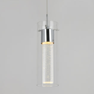 The Artika Essence LED pendant light features a cylindrical glass shade and chrome fixture, hanging from the ceiling and emitting a soft, warm glow with sparkling details inside its inner tube.
