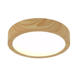 A round, ceiling-mounted light fixture with a natural wood finish and a smooth, white glowing center.