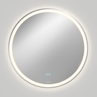 The Artika Ayla 28 in. LED mirror features a round, wall-mounted design with edge illumination, 3 CCT settings, and a built-in defogger. Two touch-sensitive icons are visible on the lower part, casting a soft glow on a plain gray wall.