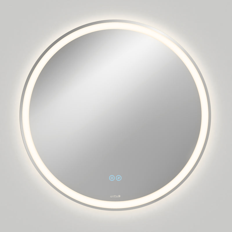The Artika Ayla 28 in. LED mirror features a round, wall-mounted design with edge illumination, 3 CCT settings, and a built-in defogger. Two touch-sensitive icons are visible on the lower part, casting a soft glow on a plain gray wall.