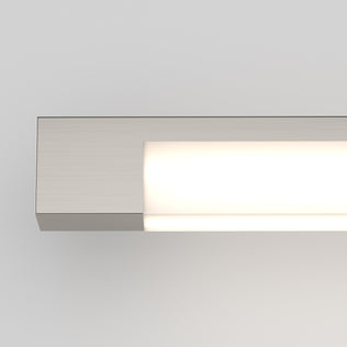The Artika Tivoli modern LED bathroom vanity light 5 CCT is a rectangular wall sconce with a brushed metal finish, mounted on a white wall. It emits a soft glow and features adjustable lighting with an LED dimmer for customizable ambiance.