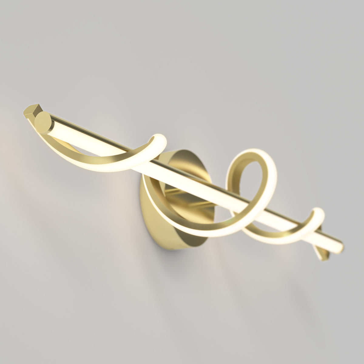 A modern gold wall sconce with a central light bar and decorative, looping curved elements, mounted on a round base against a light gray wall.