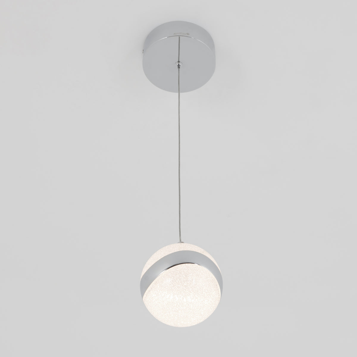 A modern pendant light with a round, frosted glass globe and a metallic accent, hanging from a thin wire attached to a circular ceiling mount against a plain white background.