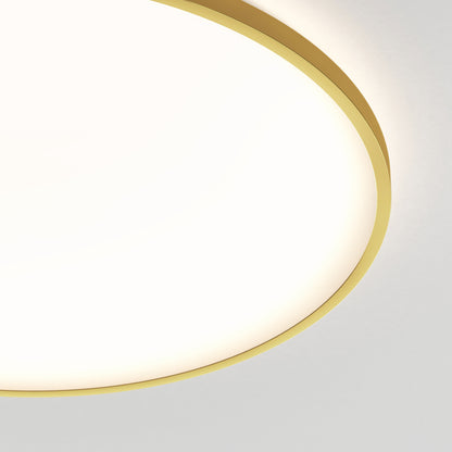 A close-up of the Artika Europa 21 in. LED modern flush mount light with remote, featuring a gold rim and glowing brightly against a white ceiling. Only part of the fixture appears in the upper left corner.