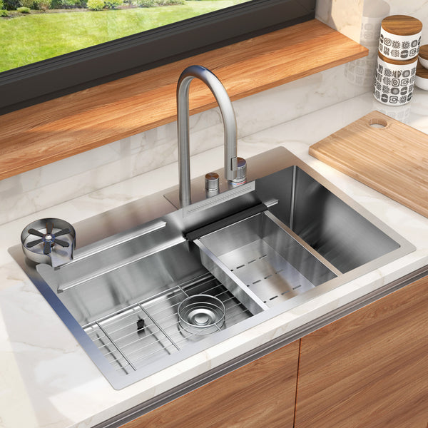 The Artika Neoflow single bowl stainless steel sink features a tall faucet, drying rack, vegetable washing area, and sits in a wooden countertop beneath a window with a cutting board and containers nearby.