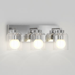 Artika Aryna 20 in. 3-Light LED Wall Vanity with three clear glass shades and glowing bulbs on a chrome rectangular backplate.