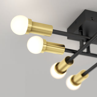 The Artika Aristo LED flush mount 3 CCT features four round bulbs on black and brass arms with adjustable color temperature.