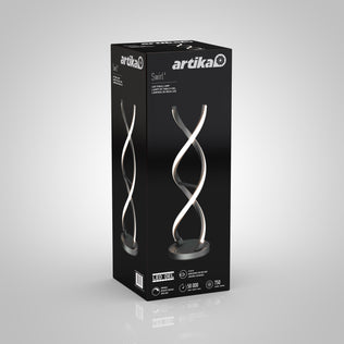 A black box displays the Artika Swirl LED Table Lamp, showcasing its modern spiral design, dimmable LED features, chrome finish branding, and product images on a minimalist background.
