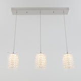 A modern ceiling light fixture with three pendant lights, each featuring a cylindrical shade adorned with crystal-like decorations, hanging from a rectangular metal base.