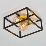 A modern ceiling light fixture with a black square metal frame, gold base, and four exposed round bulbs enclosed in glass spheres, mounted on a white ceiling.