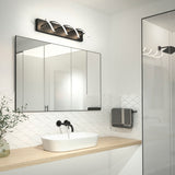 Modern bathroom with a wooden countertop, white vessel sink, black faucet, large mirrored cabinet, unique spiral light fixture above the mirror, and a towel hanging near a glass shower. Plant in a glass vase on the counter.