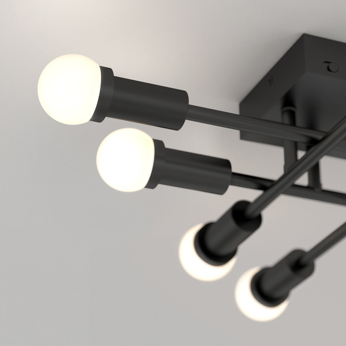 Close-up of Artika's Aristo LED flush mount 3 CCT, featuring four round bulbs on black rods and adjustable color temperature.