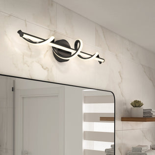The Artika Coda 27-in Integrated LED 5-CCT Vanity Light Bar is mounted above a bathroom mirror on marble tiles, with a wooden shelf and potted plant to the right, creating a stylish and modern bathroom look.