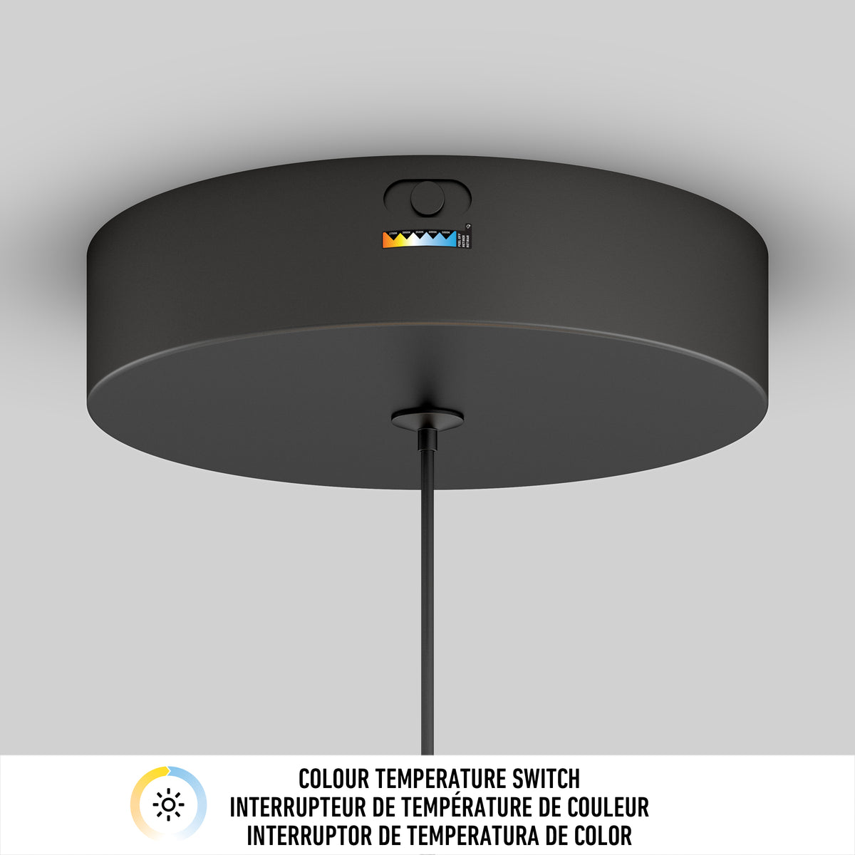 A black ceiling light fixture with a visible color temperature switch and colored indicators, mounted on a white ceiling. Below is a label in English, French, and Spanish about the color temperature switch.